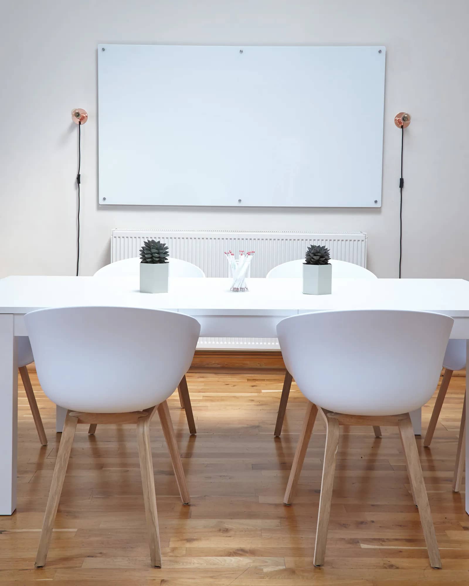 An empty meeting room with a whiteboard and a table with six chairs