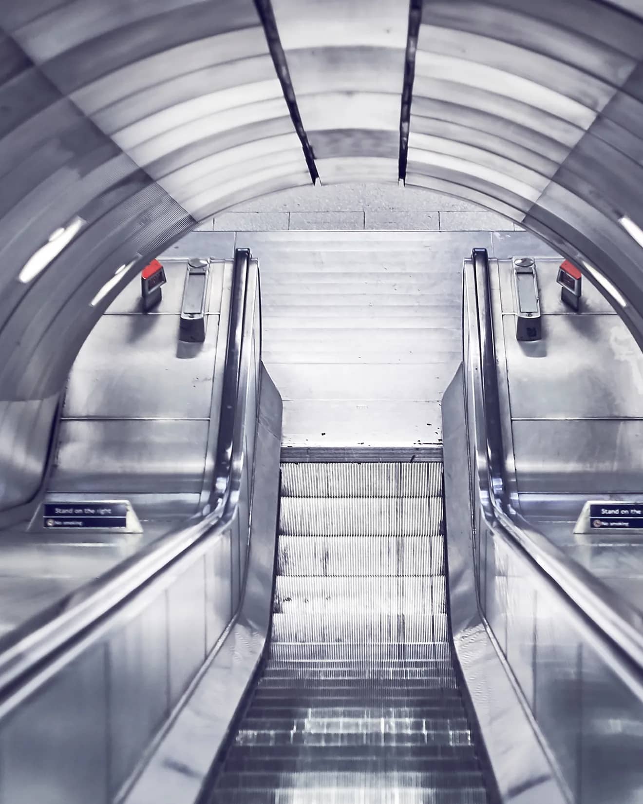 Escalators rising through a steel-clad tunnel in a London Underground station